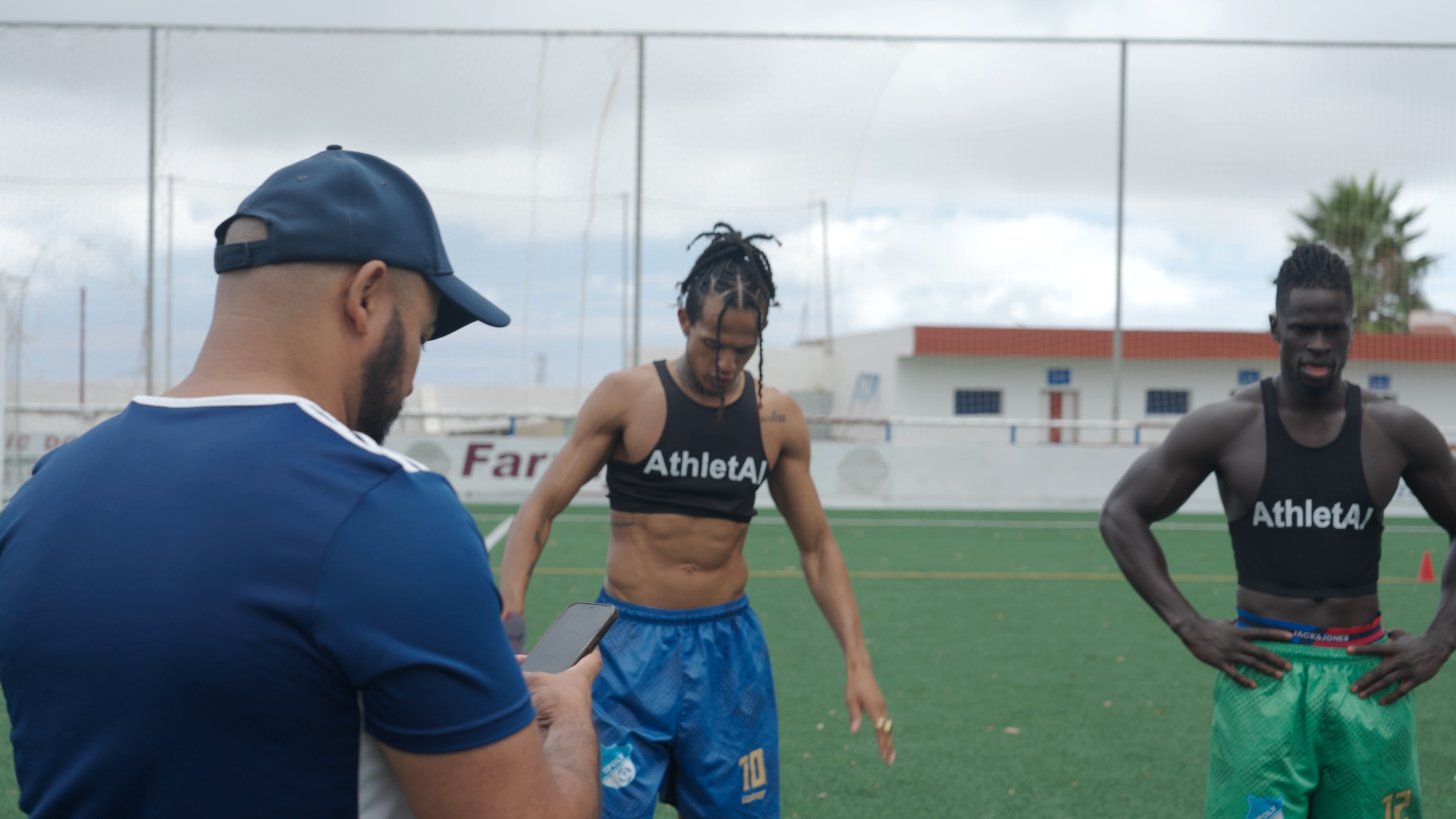 Coach reviewing information during an AthletAI field session with athletes